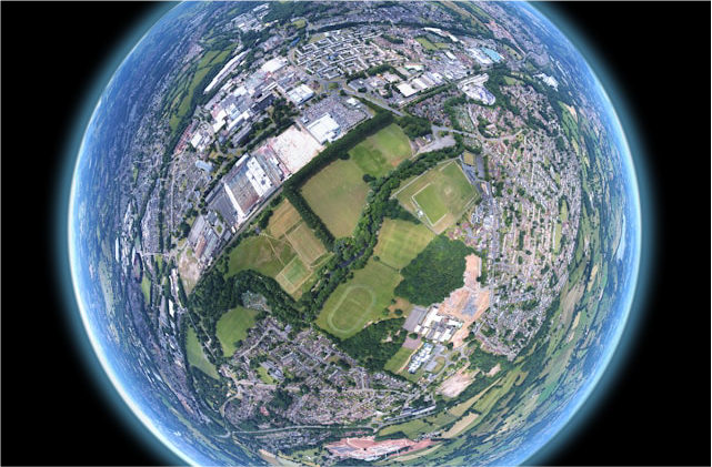 Kalasilm-efektiga satelliidifoto linnast ja rohealadest, nähtuna Maa kumeruse taustal.